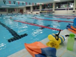 Swimming pool with flippers and pool buoy on pool edge